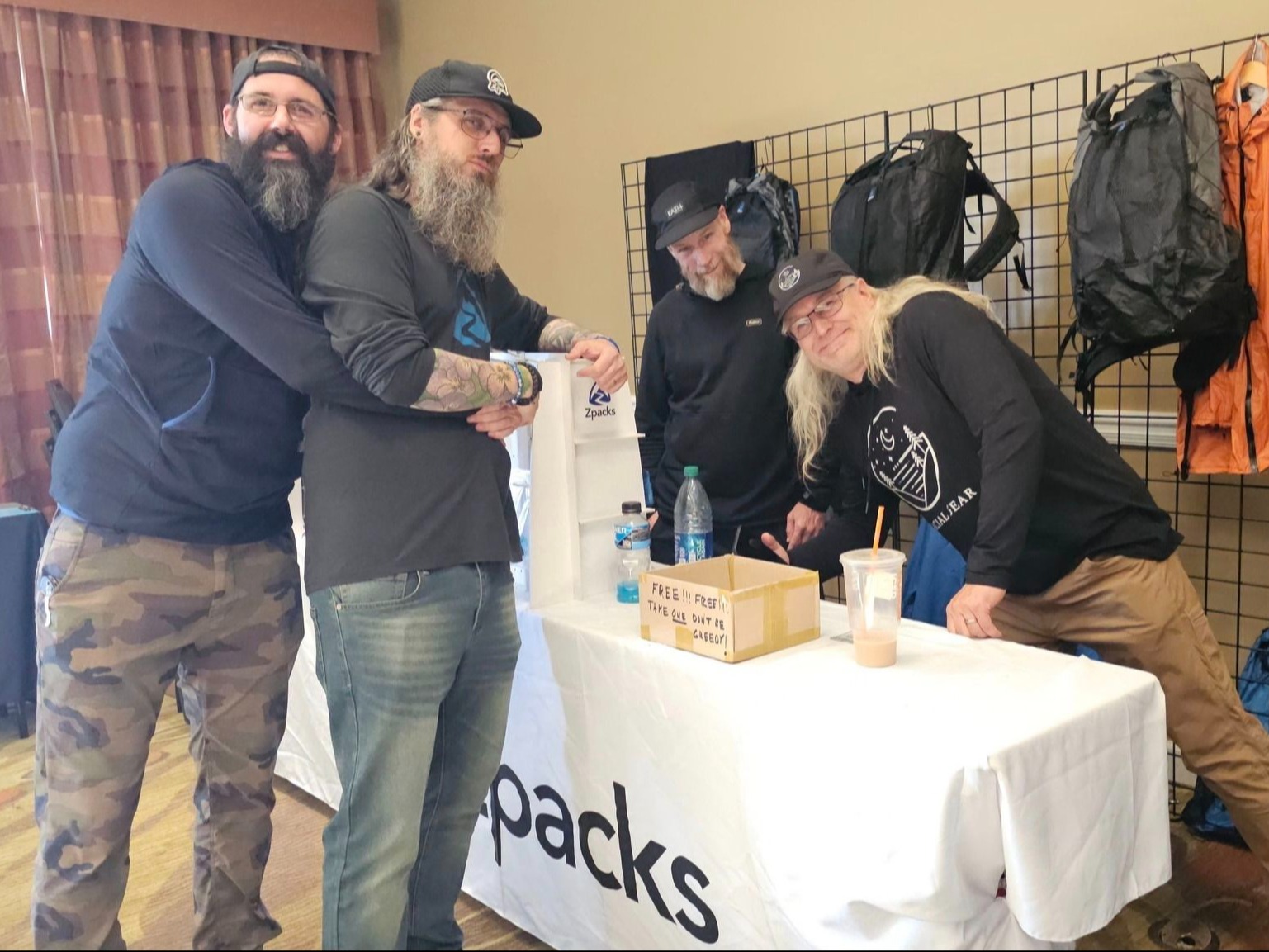 Zpacks staff joking in front of vendor table